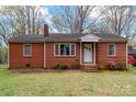 Charming red brick home featuring a classic design, a well-kept lawn, and a cozy front porch at 304 Simrill Ave, York, SC 29745