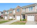A row of townhomes with a combination of brick and siding and one-car garages at 4528 Craigmoss Ln, Charlotte, NC 28278