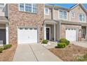 Attractive townhome showcasing a brick facade, front door, and attached one-car garage at 4528 Craigmoss Ln, Charlotte, NC 28278