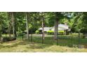 Home exterior features a fenced yard with mature trees, offering privacy and a serene setting at 4924 Riverdale Dr, Charlotte, NC 28273