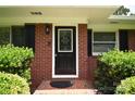 Close up of the front door with decorative glass and brick exterior detailing at 8608 Cedarbrook Dr, Charlotte, NC 28215