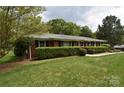 A charming ranch-style house with a well-kept lawn and a manicured privacy hedge at 8608 Cedarbrook Dr, Charlotte, NC 28215