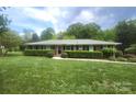 Charming brick home featuring a well-manicured lawn and lush, trimmed hedges at 8608 Cedarbrook Dr, Charlotte, NC 28215
