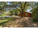 Charming brick home with a lush front yard shaded by a mature tree at 900 E Woodlawn Rd, Charlotte, NC 28209