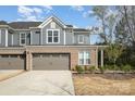Stylish townhome with brick accents, a two-car garage, and a well-maintained front yard at 9031 Odell Corners Nw Blvd, Concord, NC 28027