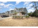 Charming townhome with a brick facade, two-car garage, manicured lawn, and a welcoming covered porch at 9031 Odell Corners Nw Blvd, Concord, NC 28027