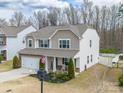 Beautiful two-story house with stone accents, a two-car garage, and a cozy front porch with rocking chairs at 10694 Sapphire Trl, Davidson, NC 28036
