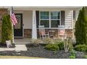 Close-up of the cozy front porch with rocking chairs, decorative plants, and stylish exterior details at 10694 Sapphire Trl, Davidson, NC 28036