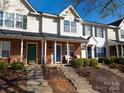 A cozy townhouse boasts brick and siding, complemented by a well-manicured lawn and inviting entryways at 107 Forester St, Mooresville, NC 28117