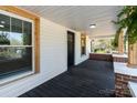 Inviting front porch with rustic wood trim and a dark wood floor with brick and concrete pillars at 1545 7Th Avenue Sw Dr, Hickory, NC 28602