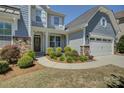 Inviting home exterior showcases a manicured lawn, stone accents, and a charming covered porch with elegant details at 16524 Palisades Commons Dr, Charlotte, NC 28278