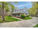 Beautiful two-story home with a sprawling porch, showcasing curb appeal and a tranquil setting surrounded by lush greenery at 2095 Westridge Dr, Rock Hill, SC 29732