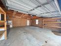 Spacious garage interior with concrete floor, exposed ceiling, white door, window, and built-in shelving at 245 Clontz Hill Rd, Troutman, NC 28166
