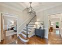 A foyer with a staircase and hardwood floors, lit by a modern pendant light fixture at 2605 Winding Oak Dr, Charlotte, NC 28270