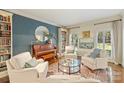Cozy living room featuring a piano, bookshelves, and comfortable seating at 2605 Winding Oak Dr, Charlotte, NC 28270