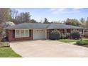 A brick home is shown with an attached garage and long driveway at 317 S Lineberry St, Troy, NC 27371