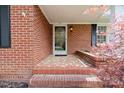 A covered front entrance showcases a tiled floor and a charming brick wall at 317 S Lineberry St, Troy, NC 27371