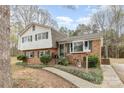 Inviting brick home with green shutters, a cozy front porch, and a well-maintained walkway at 4603 Oakwood Cir, Gastonia, NC 28056