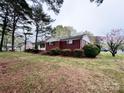 Side view of the home, highlighting the brick exterior and landscaped surroundings on a lush lawn at 511 W Main St, Cleveland, NC 27013