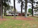 View of the home and expansive front yard, framed by mature trees and greenery, creating a serene setting at 511 W Main St, Cleveland, NC 27013