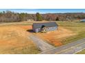 New construction home with gray siding, dark roof, and a covered front porch, nestled on a sizable lot near wooded area at 629 Mt. Wesley Church Rd, Hiddenite, NC 28636