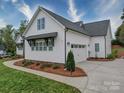 Home exterior featuring a two-car garage, well-maintained lawn, and tasteful landscaping at 630 Deese Rd, Monroe, NC 28110