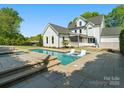A modern backyard featuring a pool with built-in loungers and a lush green lawn at 6700 Folger Dr, Charlotte, NC 28270