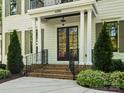 Elegant home entrance featuring a brick staircase, black framed door, and white pillars at 6700 Folger Dr, Charlotte, NC 28270