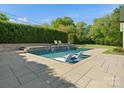 Inviting pool area featuring in-pool loungers, stone accents, and mature landscaping at 6700 Folger Dr, Charlotte, NC 28270