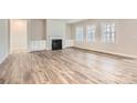 Spacious living room featuring a fireplace, built-in cabinets, three large windows, and stylish flooring at 7009 New Town Rd, Waxhaw, NC 28173