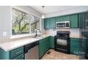 A functional kitchen with green cabinets and modern appliances at 8224 Park Vista Cir, Charlotte, NC 28226