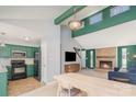 Open floor plan with green kitchen leading into living room with brick fireplace at 8224 Park Vista Cir, Charlotte, NC 28226
