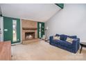 A well-lit living room featuring a brick fireplace and comfortable blue sofa at 8224 Park Vista Cir, Charlotte, NC 28226