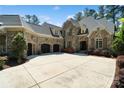 Stone home featuring a circular driveway and three car garage at 9011 Pine Laurel Dr, Weddington, NC 28104