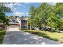 Spacious home featuring a long driveway, two-car garage, and lush green lawn at 10429 Madison Park Dr, Charlotte, NC 28269