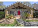 Close-up of the beautiful stone home with a covered entry and a striking red front door at 118 Lakewood Dr, Kings Mountain, NC 28086