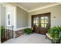 Inviting covered front porch featuring double doors, stone accents, and tasteful decor at 125 Trent Pines Dr, Mooresville, NC 28117