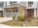 Close-up view of the garage and front garden, showcasing brick and vibrant landscaping at 1268 Scotch Meadows Loop, Monroe, NC 28110