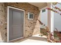 Stylish gray front door with brick surround, offering a warm welcome to the home at 1268 Scotch Meadows Loop, Monroe, NC 28110