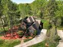 A bird's eye view of the home, surrounded by mature trees and showcasing the landscaping and backyard at 13620 Castleford Dr, Mint Hill, NC 28227