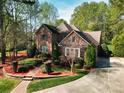 Charming two-story brick home featuring lush landscaping, a stone pathway, and a well-manicured lawn at 13620 Castleford Dr, Mint Hill, NC 28227