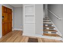 Inviting entryway featuring wood floors, built-in shelves, stairs, and a classic wood door at 1801 Weststone Dr, Charlotte, NC 28208