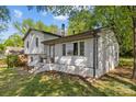 Charming two-story home featuring a white brick facade, black trim, and inviting front steps at 1801 Weststone Dr, Charlotte, NC 28208