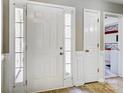 Bright foyer features a front door with sidelights, wood flooring, and white trim at 2020 Makin Dr, Indian Trail, NC 28079