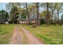 A glimpse of a quaint home nestled among lush trees and greenery, offering a serene, private setting at 2131 Wildlife Rd, Charlotte, NC 28214