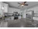 Well lit kitchen with white cabinets, stainless steel appliances and a ceiling fan at 2439 Heathershire Ln, Matthews, NC 28105