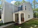 Two-story home featuring gray siding, stone accents, and a covered front porch at 2752 Bramble Ridge Ct, Charlotte, NC 28215
