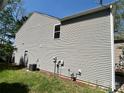 View of the side of the home featuring gray siding, an AC unit, and electrical and plumbing elements at 2752 Bramble Ridge Ct, Charlotte, NC 28215