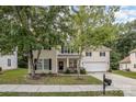 Two-story home with mature trees, covered porch, and a driveway leading to a two-car garage at 3009 Early Rise Ave, Indian Trail, NC 28079