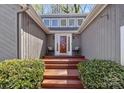 Inviting entryway with wood steps, chairs and a decorative glass front door at 3489 Lake Shore S Rd, Denver, NC 28037